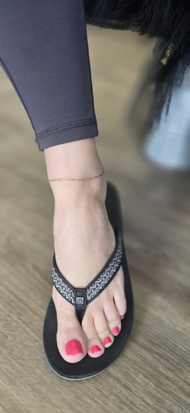 Fine chain anklet worn with black flip flops
