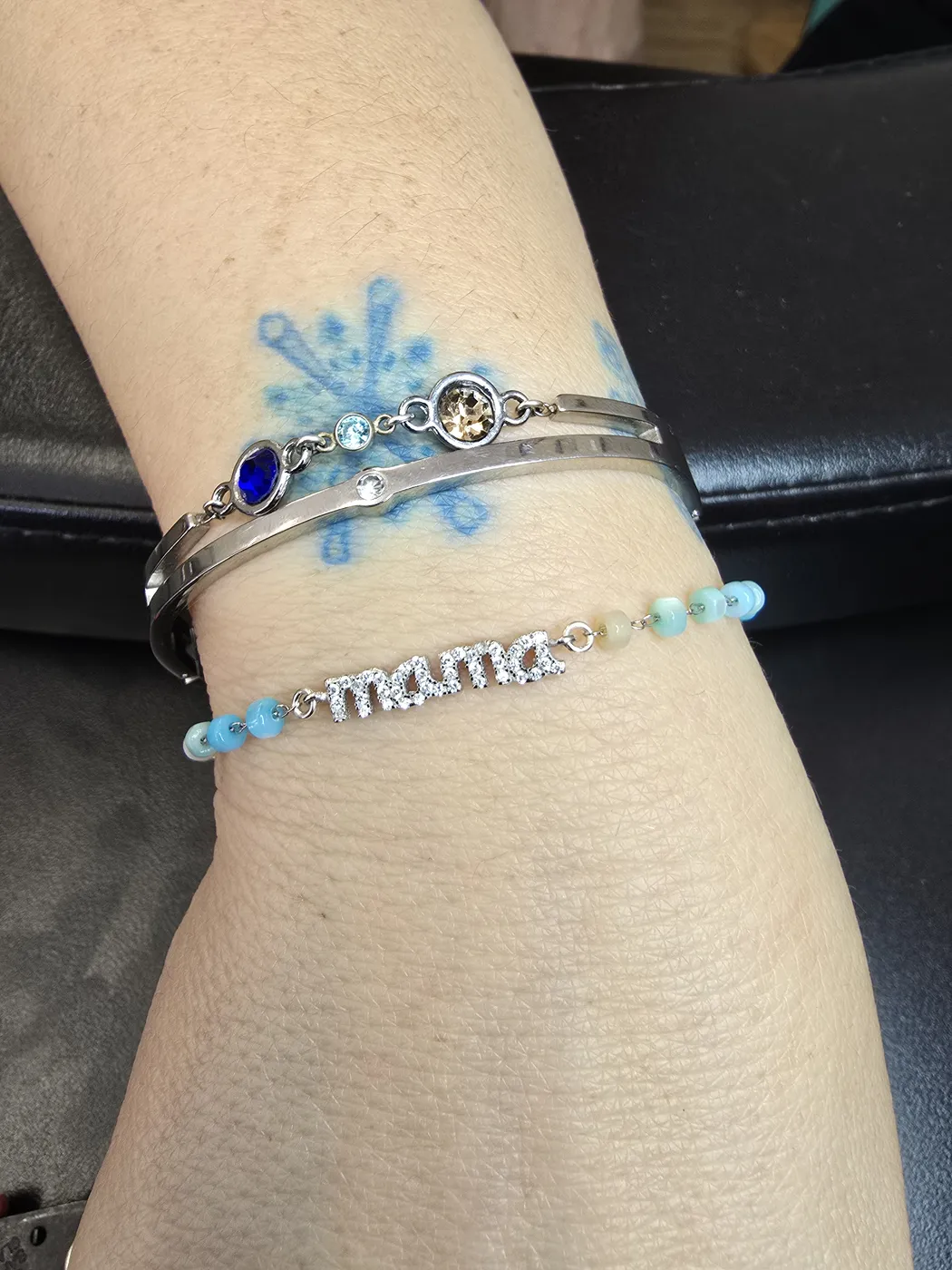 Stack of bracelets including a blue beaded mama bracelet