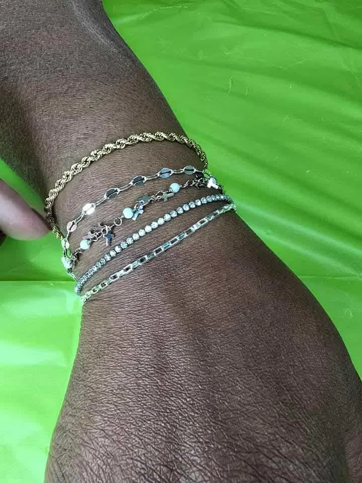 Stack of silver and gold chain bracelets on a client's wrist