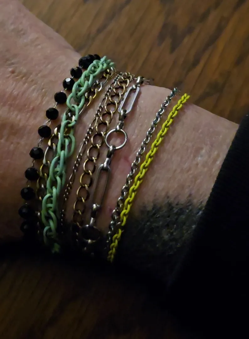 Colorful stack of chain bracelets in mint, gold, silver and yellow