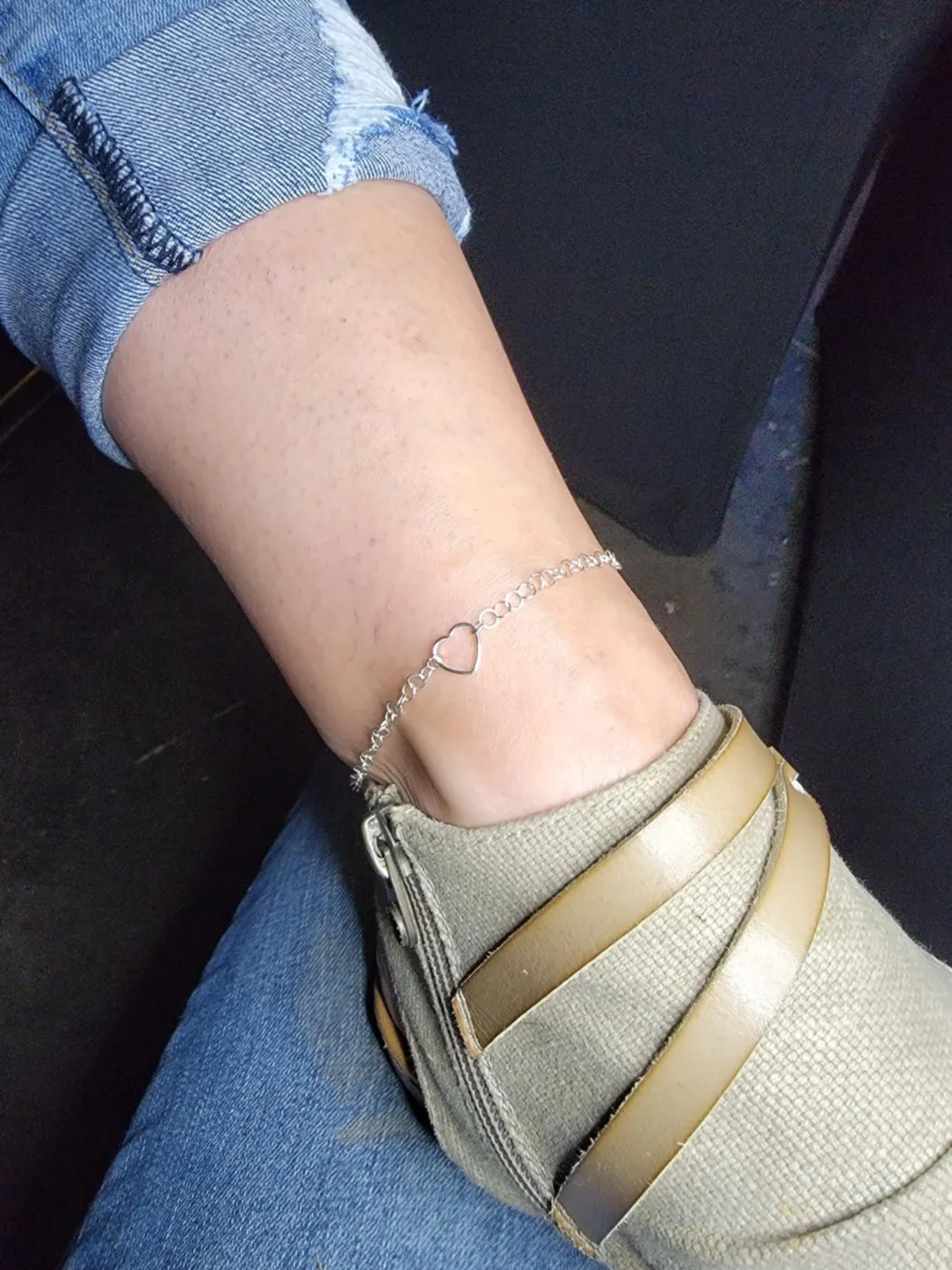 Fine anklet with an open heart link worn with metallic flats