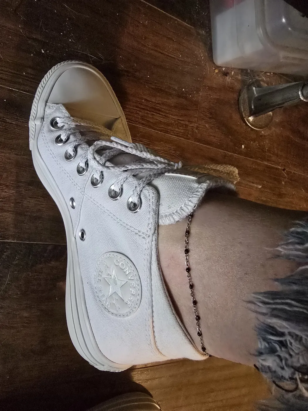 Black beaded anklet worn with white high top sneakers