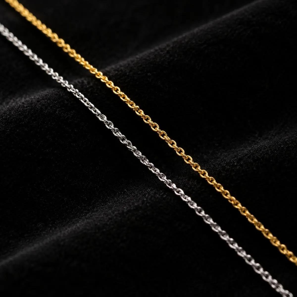 Gold and silver fine chains laid side by side on black velvet