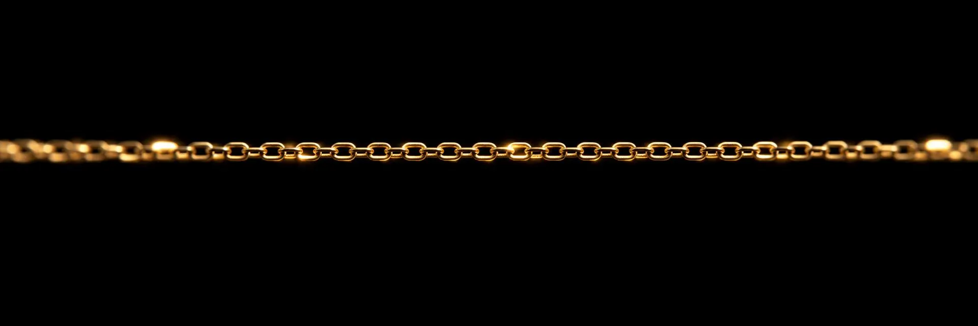 Long fine gold chain stretched across black