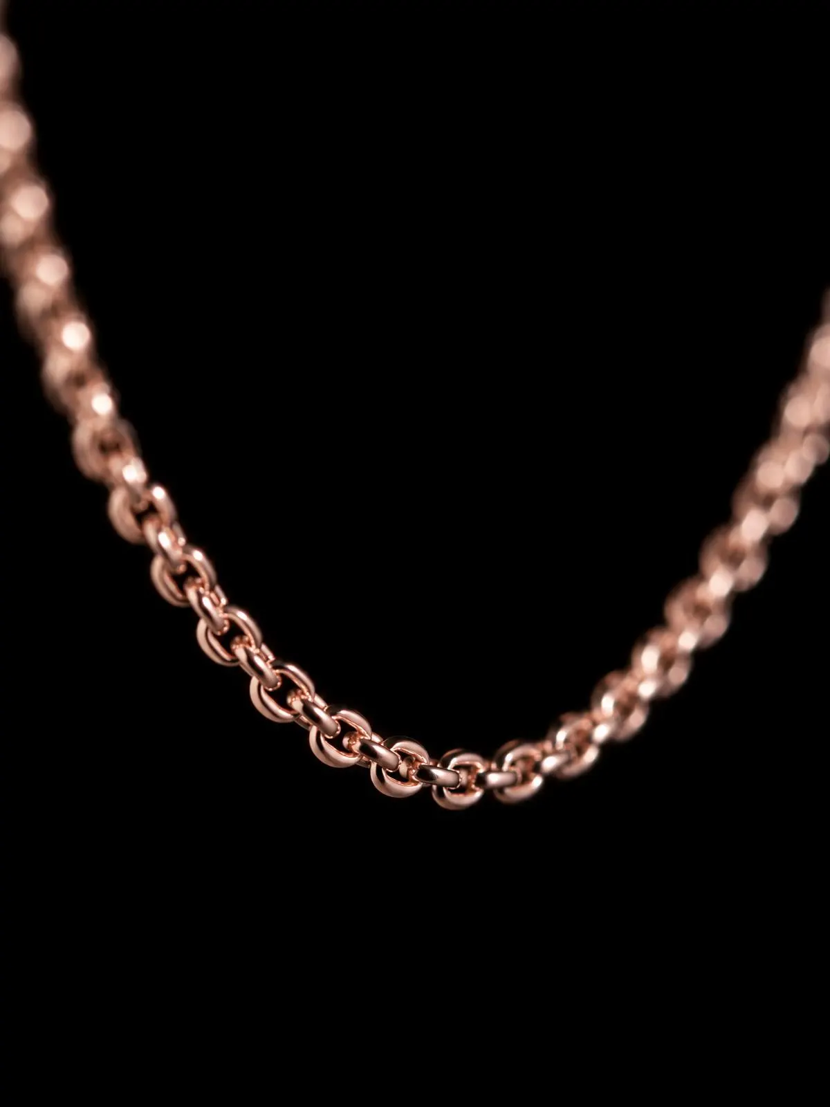 Macro of a fine rose gold-filled chain on black